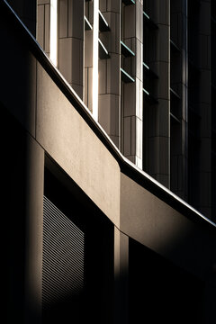 Dark modern facade in London England shows dramatic light shadow geometry and abstract architectural detail within a contemporary urban building