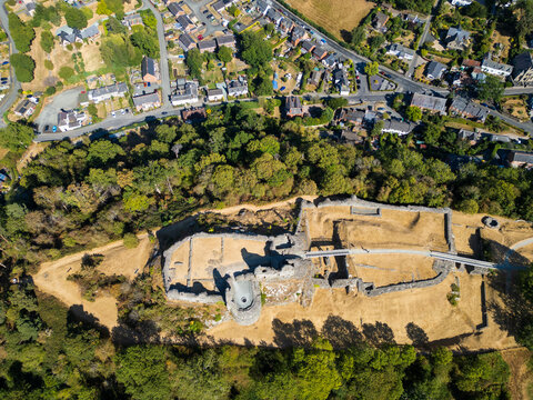Aerial view of the historic stone ruins of Montgomery Castle surrounded by lush trees and grassy grounds near the town of Montgomery, Wales, United Kingdom.