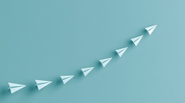 A sequence of light blue paper airplanes soaring upwards in a curved path. This represents growth, success, and business strategy concepts for corporate marketing.