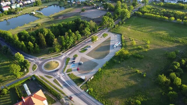 Aerial drone view showing the Camaldolese Monastery with white and orange buildings beside a pond. Trees fields and roads surround the complex in Wigry Poland