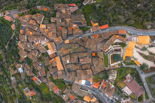 Aerial view of the historic village with dense terracotta rooftops, narrow winding streets, and surrounding lush greenery in Anversa degli Abruzzi, Abruzzo, Italy.