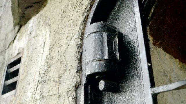 Close view of an old metal hinge on a fortified bunker door