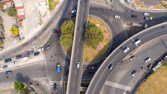 Aerial view of the Jombor Flyover with multi-level road intersections and flowing traffic surrounded by urban greenery in Yogyakarta, Special Region of Yogyakarta, Indonesia.