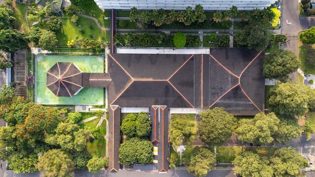 Aerial view of the historic building complex with traditional roof architecture surrounded by lush trees and gardens in Yogyakarta, Special Region of Yogyakarta, Indonesia.