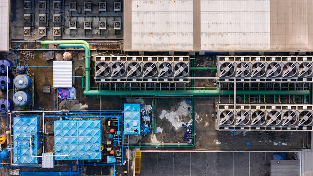 Aerial view of industrial HVAC cooling systems and water tanks installed on a flat rooftop in Yogyakarta, Special Region of Yogyakarta, Indonesia.
