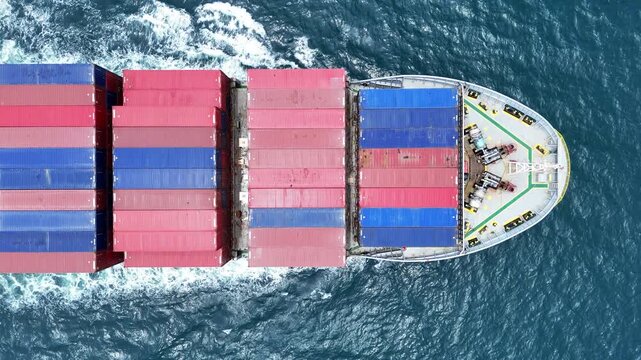 Aerial top view of cargo ship with contrail in the ocean sea ship carrying container and running from container international port smart freight shipping by ship service