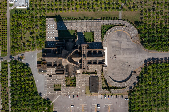 Aerial view of Basilica Nuestra Senora De La Altagracia surrounded by palm trees, paved courtyards, and a parking lot in Higuey, La Altagracia Provinc, Dominican Republic.