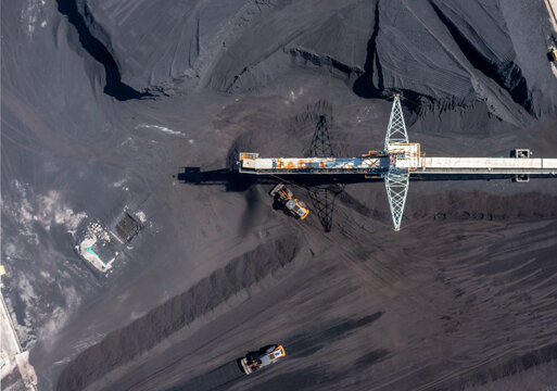Aerial view of Barahona Coal Power Plant and Industrial Port with heavy machinery moving coal piles in Barahona, Barahona Province, Dominican Republic.