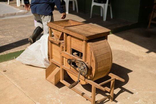 Traditional wooden winnowing machine for black pepper processing, manual sorting and cleaning peppercorns on agricultural farm
