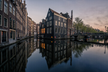 Fototapeta premium Traditional Amsterdam canal houses reflected in water at blue hour