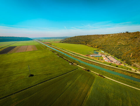 Aerial view of the Mirna river canal flowing through lush green agricultural fields and rural landscape near Brtonigla, Istria County, Croatia.