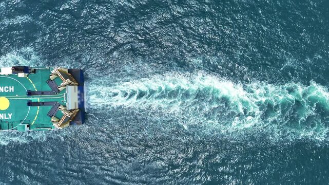 Aerial top view of cargo ship with contrail in the ocean sea ship carrying container and running from container international port smart freight shipping by ship service