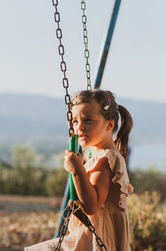 Happy Little Girl Enjoying a Summer Vacation on a Swing in Greece