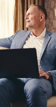 Remote work, thinking or man in hotel with laptop, funding proposal or reflection in budget review. Smile, freelance or mature finance advisor with tech, risk evaluation or investment idea for pitch