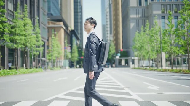 Japanese businessman crossing a quiet street in the Tokyo business district