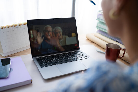 Video call to elderly couple from home office desk