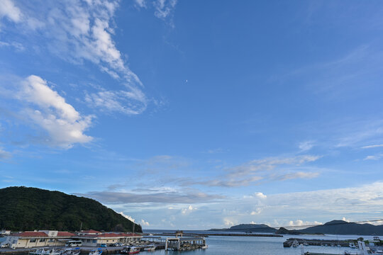 夏の青空と白い雲が広がる沖縄・座間味島の港と慶良間の島々を望む風景【沖縄風景写真】