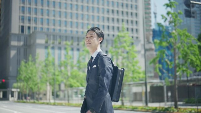 Businessman walking away down a wide street in central Tokyo