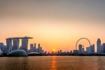 Singapore skyline at sunset with Marina Bay Sands, Singapore Flyer, and city reflected in the calm bay © Nikolay N. Antonov