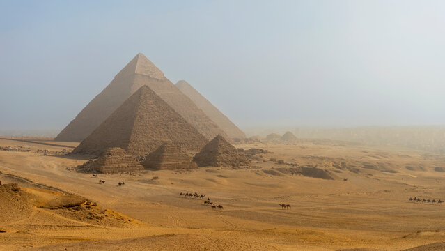 Majestuosas pir&aacute;mides de Guiza en el desierto de Egipto bajo una atm&oacute;sfera brumosa