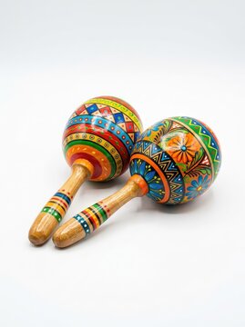A vibrant pair of hand-painted wooden maracas, decorated with traditional colorful patterns, isolated against a pure white studio background, traditional, shakers, swirls