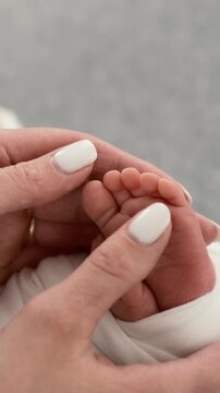 Mom Ticking Baby's Feet In A Close-Up Vertical Video