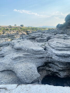 Rugged gray karst landscape featuring layered, eroded rock formations under a clear sky