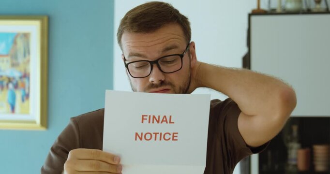 Worried man reading a final notice letter, representing an urgent warning, overdue payment, debt collection and last reminder.