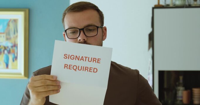 Man reading a signature required notice, representing document signing, authorization, agreement and official paperwork.