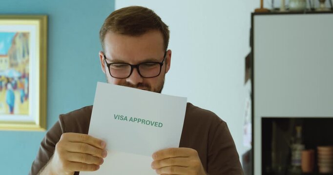 Happy man celebrating after reading a visa approval letter, representing successful immigration application, travel permission and positive decision.