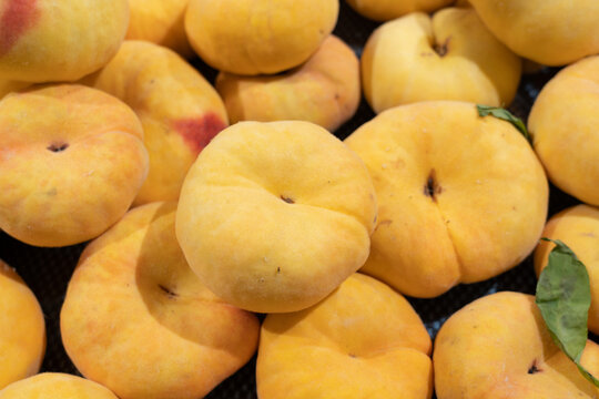 Piled Flat Peaches on Market Display