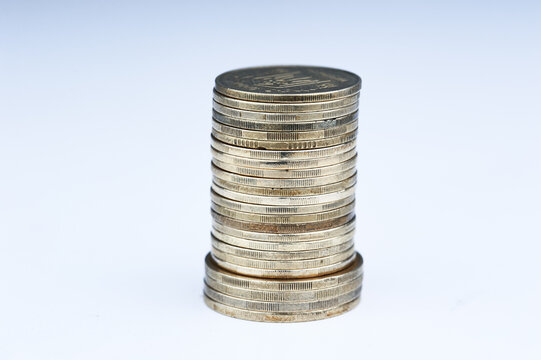 A close-up stack of coins on a clean white background symbolizing money, savings, investment and financial growth for business, budgeting, banking and economic concepts.