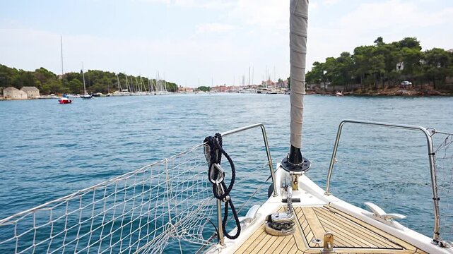 Sailing yacht entering the harbor of Stari Grad on Hvar Island. View from the bow approaching one of the oldest ports on the Adriatic Sea.