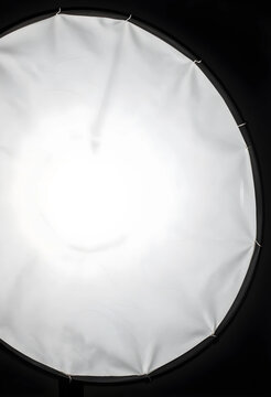 Photography lighting and studio production, circular softbox diffuser glowing with bright light for professional video and portrait session equipment