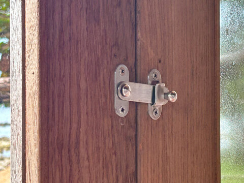 Flip Latch on wooden folding door is closed.