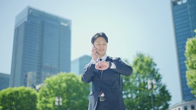 Businessman talking on a smartphone against a backdrop of high rise buildings