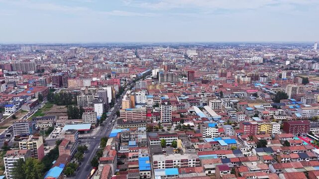 Aerial view of small Chinese city with dense residential buildings under blue sky