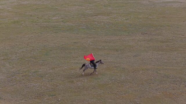 Aerial view of horseman with flag in Song Kol, Kyrgyzstan.