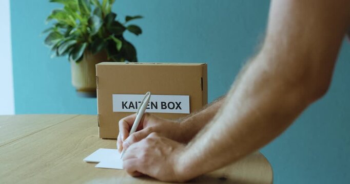 Man writing a Kaizen improvement idea for a suggestion box, representing continuous improvement, lean management and employee participation.