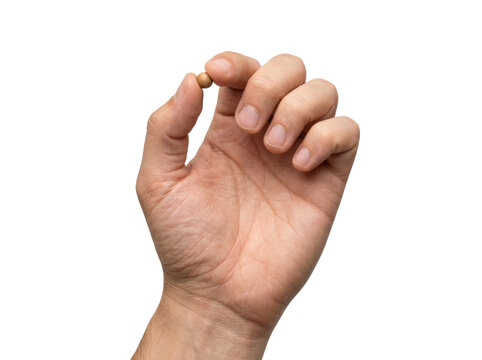 Close up of a human hand holding a small object between thumb and forefinger.