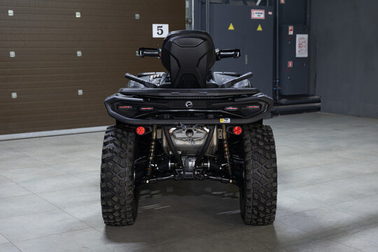 A rugged, aggressive black BRP Outlander ATV isolated on a solid black background. Powerful stance, mud-terrain tires, and detailed off-road design. Sharp studio lighting highlights the metallic frame