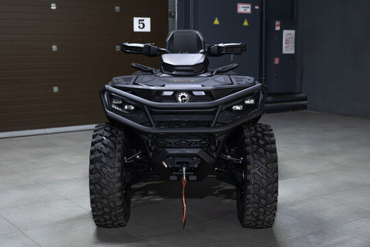 A rugged, aggressive black BRP Outlander ATV isolated on a solid black background. Powerful stance, mud-terrain tires, and detailed off-road design. Sharp studio lighting highlights the metallic frame
