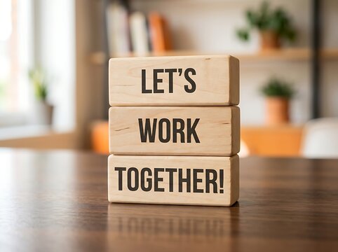 Wooden blocks stacked on a wooden table displaying the text let's work together with collaboration together teamwork