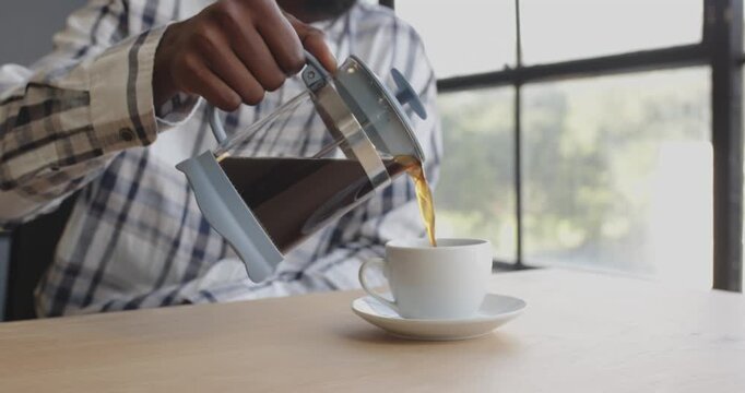 Man enjoying coffee break at office, holding cup near window, relaxing moment