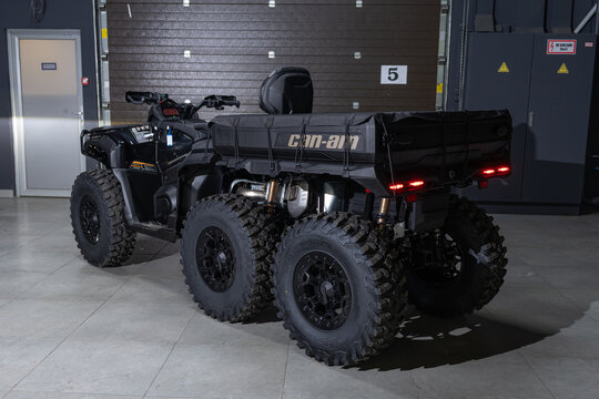 A massive black 6x6 BRP Outlander MAX ATV isolated on a solid black background. Rugged multi-axle design, aggressive stance, heavy-duty build, and sharp studio lighting emphasizing the powerful off-ro