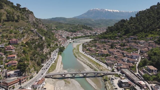 Berat, albania historic city panorama showing osum river, old bridge, and traditional houses with mountains in background