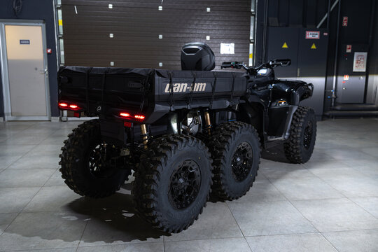 A massive black 6x6 BRP Outlander MAX ATV isolated on a solid black background. Rugged multi-axle design, aggressive stance, heavy-duty build, and sharp studio lighting emphasizing the powerful off-ro