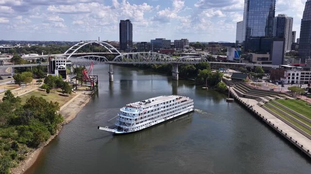 Drone aerial shot of a sightseeing boat as it turns around on the Cumberland River just outside of Nashville downtown