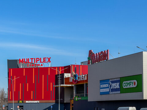Kyiv, Ukraine - March 13, 2026: McDonalds building signage with Multiplex, Auchan, Decathlon, Jysk, and Comfy logos at a large commercial shopping mall exterior against a blue sky