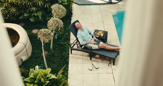 Man, relax and stretching with laptop by swimming pool for break or accommodation in resort. Top view, male person or chilling with computer on chair by poolside for vacation, rest or weekend retreat